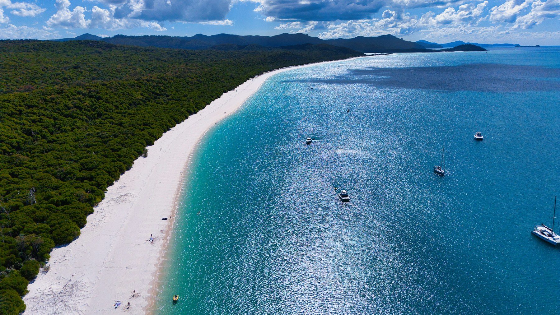 Whitehaven Beach shoreline and sailboats seen from above in the Whitsundays